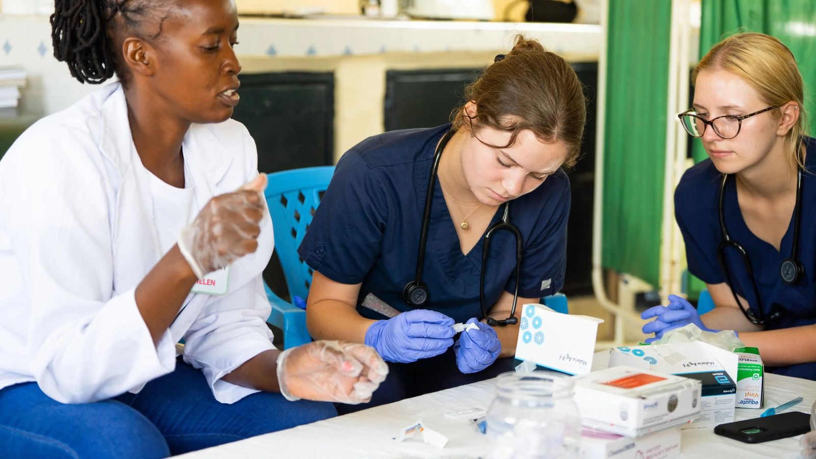 Nursing students preparing supplies beside a caregiver