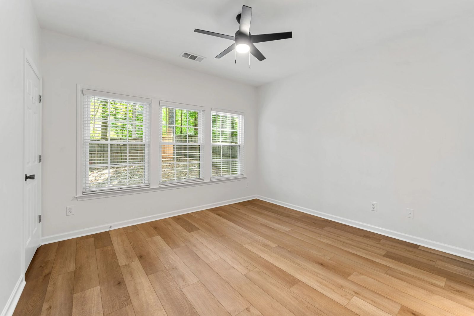A sunlit bedroom with large windows