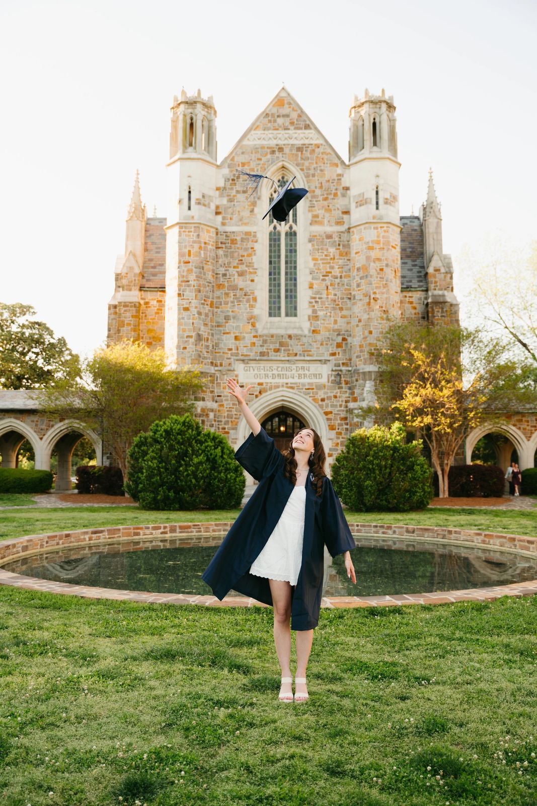 A graduate in front of a gothic chapel