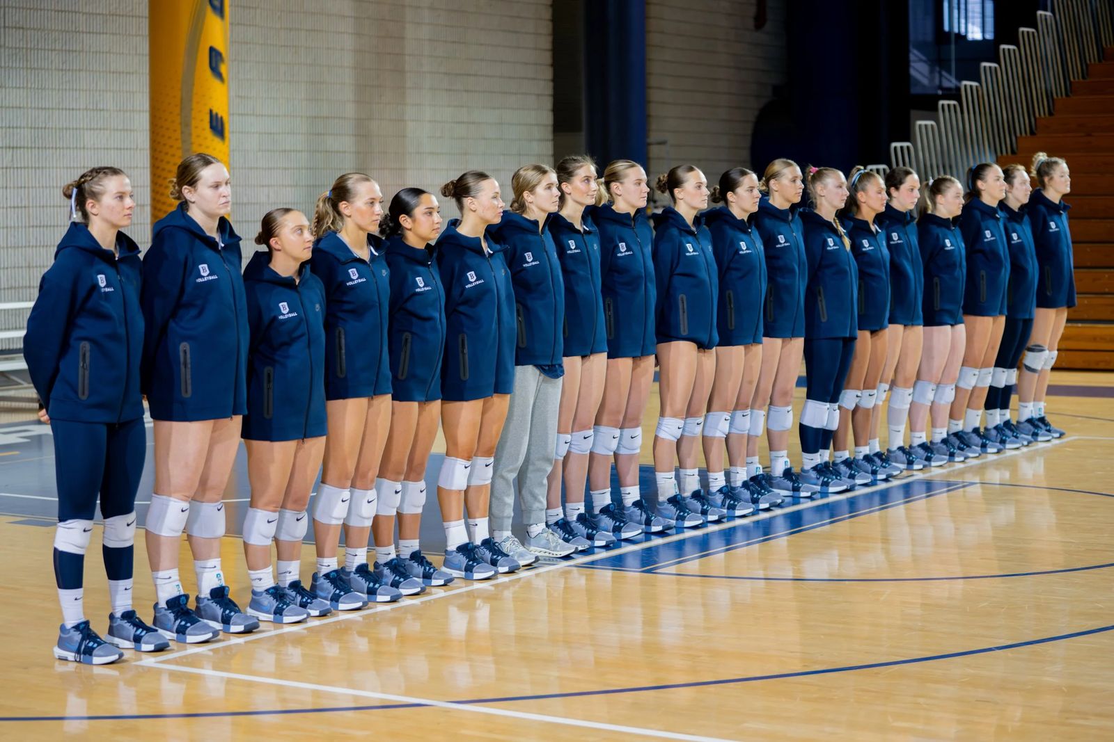 A full volleyball roster lined up on the court before a match