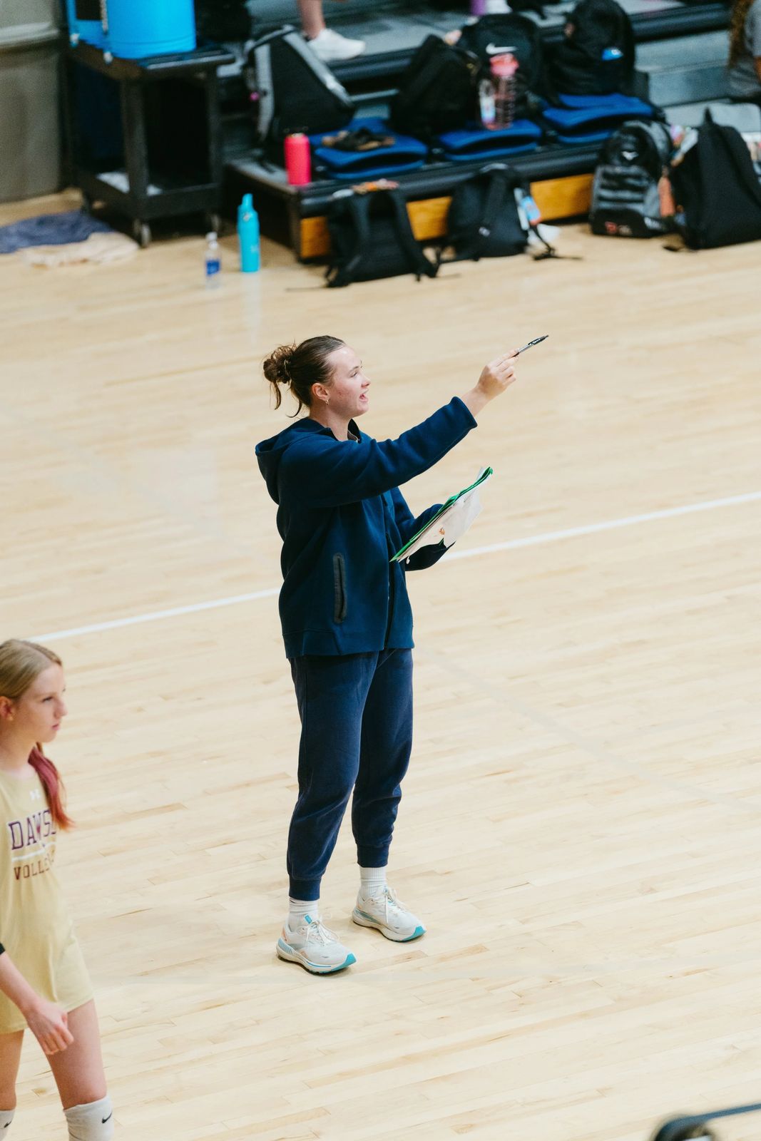 A coach directing practice from the court