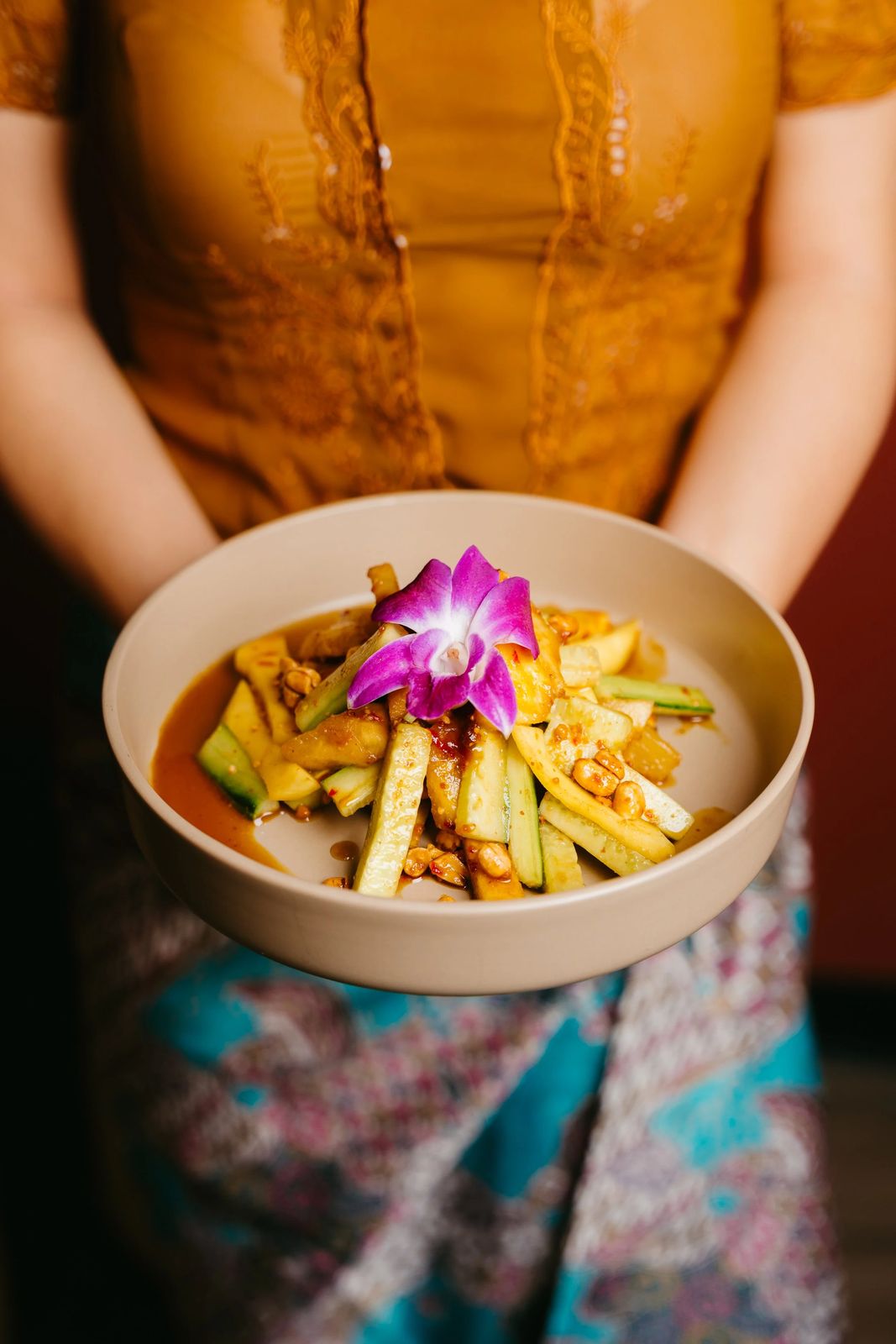 A server holding a plated Gula dish
